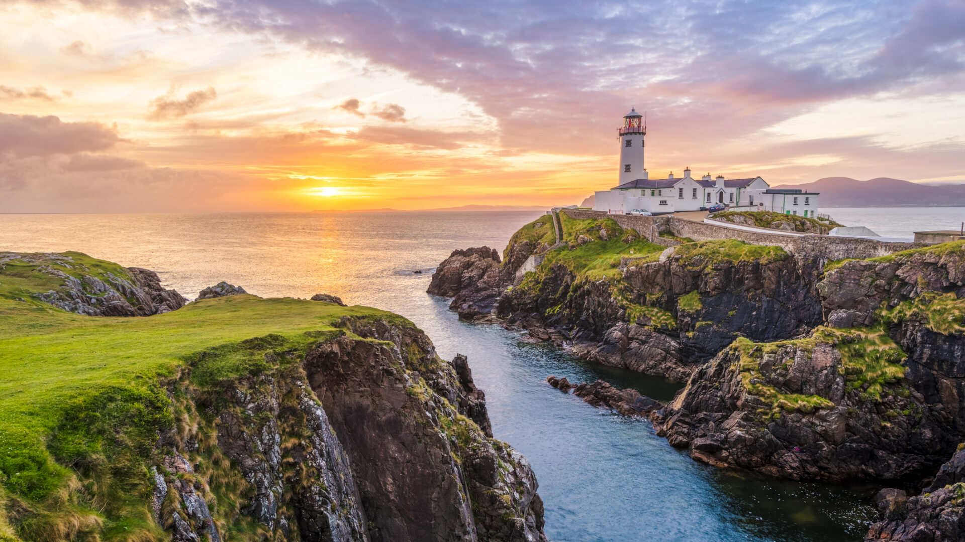 Ierland: Vuurtoren op de kliffen van Donegal tijdens een kleurrijke zonsondergang, een perfecte bestemming voor natuurliefhebbers