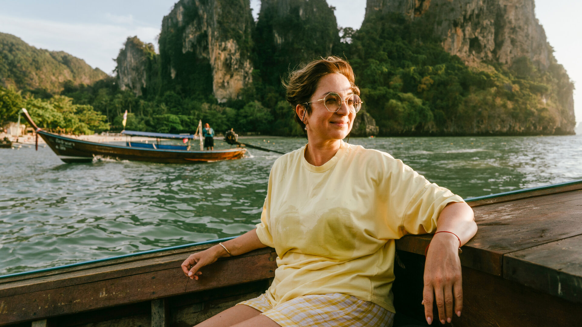 Vrouw geniet van een ontspannen boottocht in Thailand tijdens haar soloreis