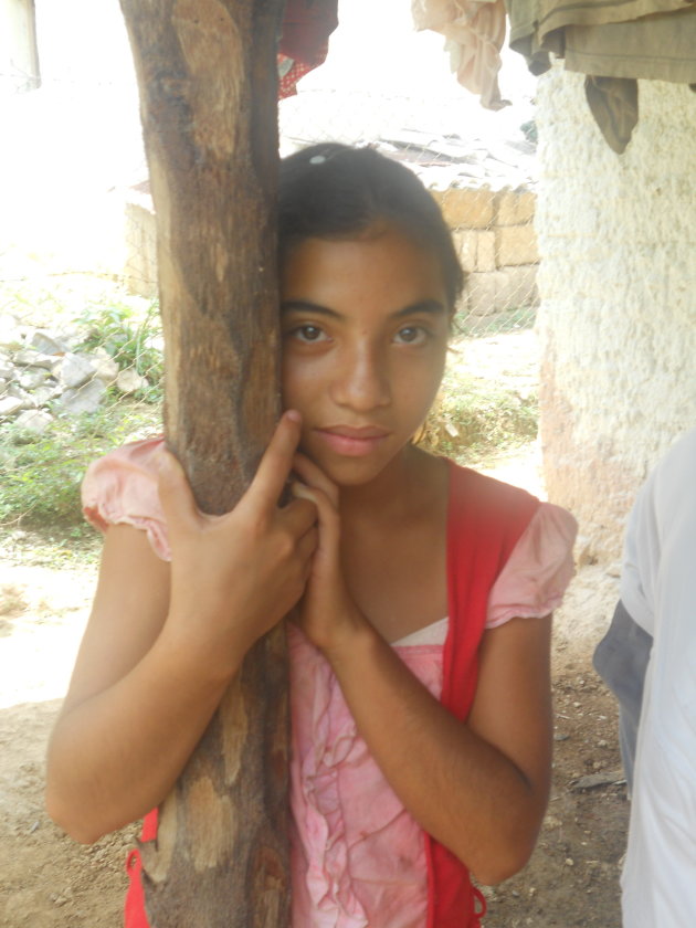 Op bezoek bij mensen thuis, in de gemeenschap El Espíritu, in de regio Florida, Noord-west Honduras. Meisje kijkt verlegen toe.