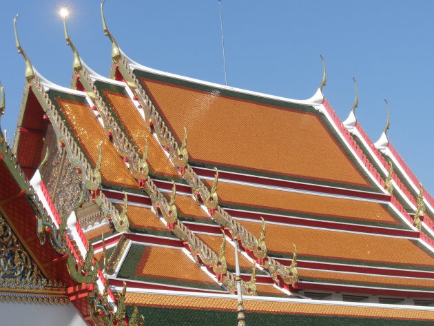 Zon schittert op het dak van een tempel bij What Pho, Bangkok