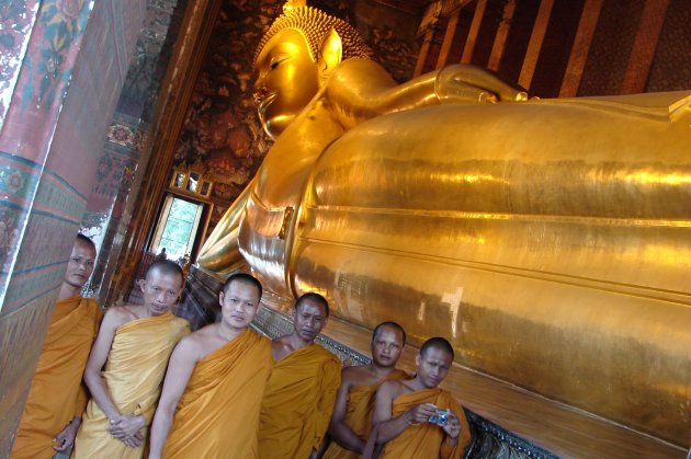 Monniken in de Wat Pho in Bangkok voor de liggende Boeddha