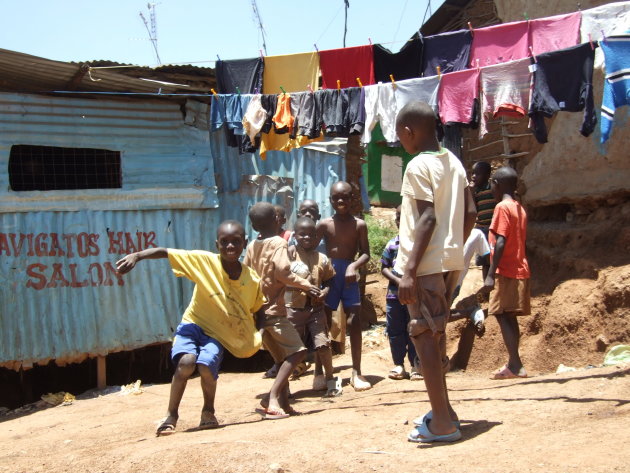 Kleurrijk straatbeeld in kleurloos Kibera