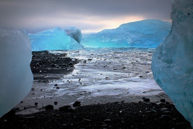 Blauw Gletsjer-IJs op Zwart Strand