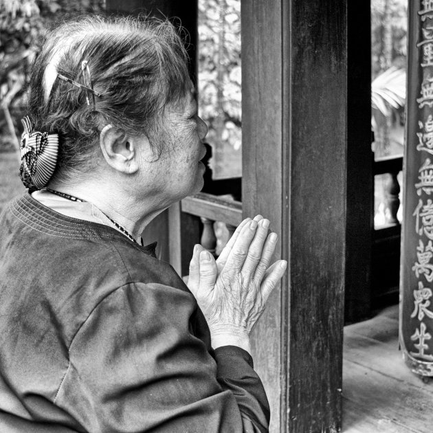 Biddende vrouw bij tempel Hanoi bij Ho Chi Minh Mausoleum