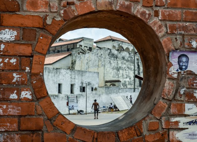 Elmina door een gat in de muur