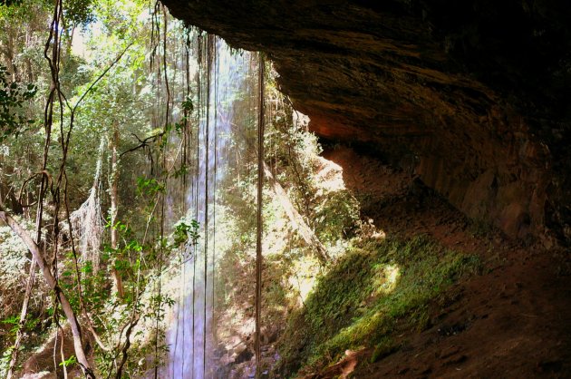 Behind the waterfall.