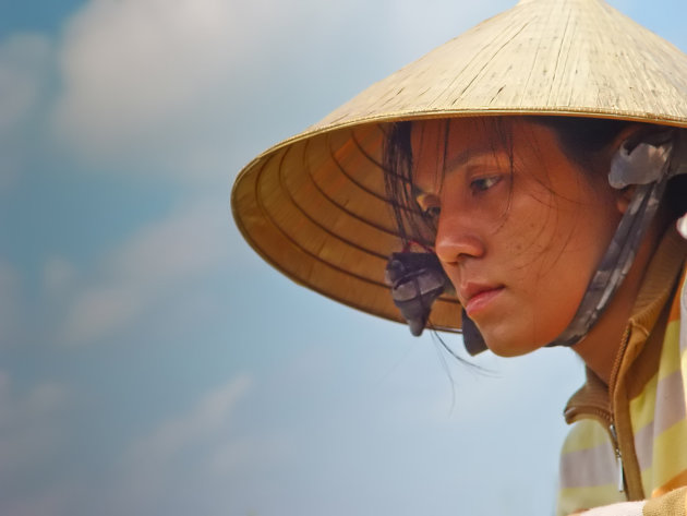 Zij schilt de ananassen op een boot bij “Cai Be” in de Mekong delta.