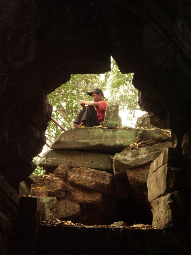 Doorkijkje rustende jongeman in Angkor Wat