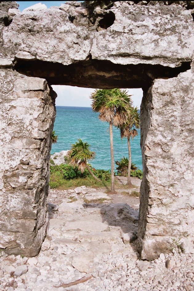 Zicht op zee, door een ruïne in Tulum