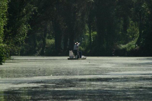 Een oude boer vaart door de drijvende tuinen