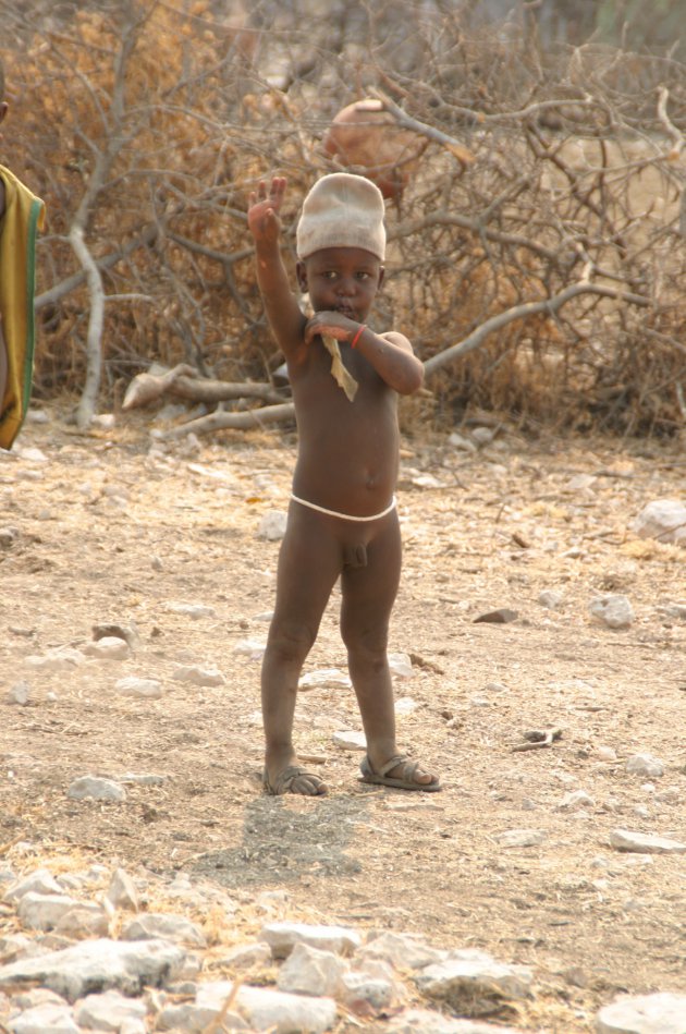 Een himba jongetje wuift ons uit