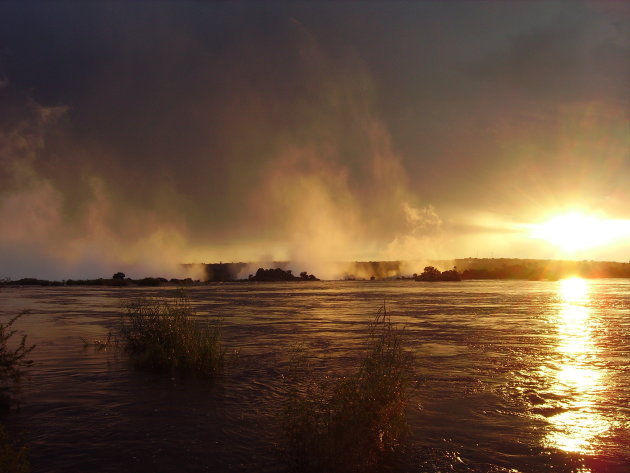 Zonsondergang over de Victoria watervallen en Zambezi rivier