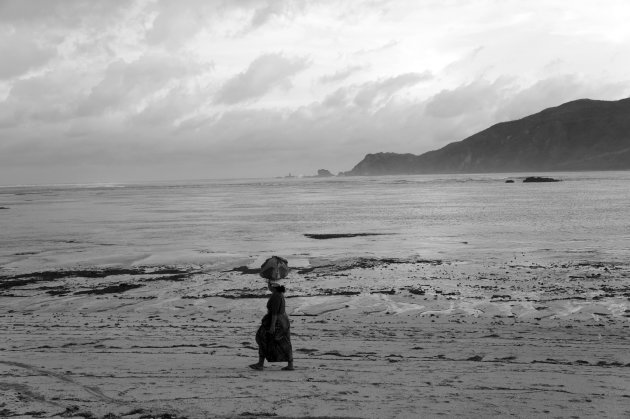 Sarong verkoopster op verlaten strand