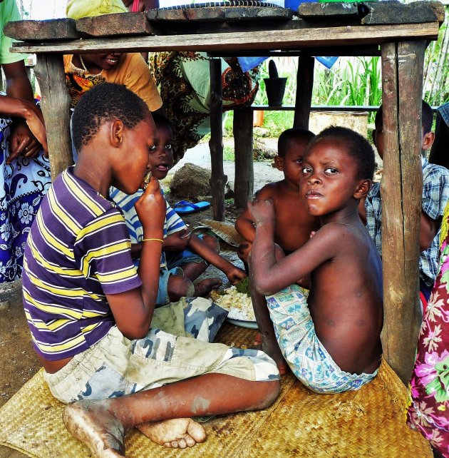 Kinderen eten samen onder tafel