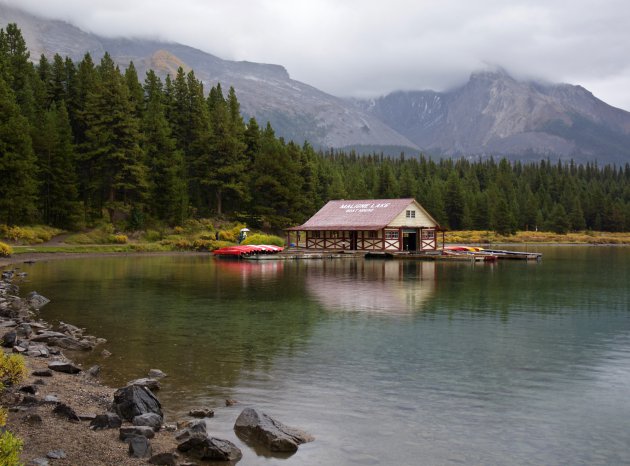 Laag hangende mist bij de bergen achter op Maligne Lake 