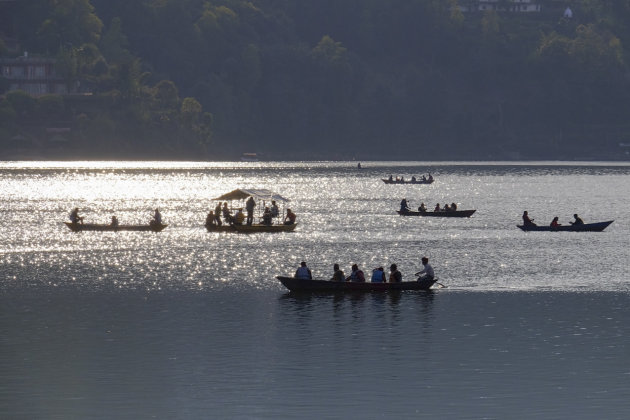 Boten op het Pokhara Lake bij zonsondergang