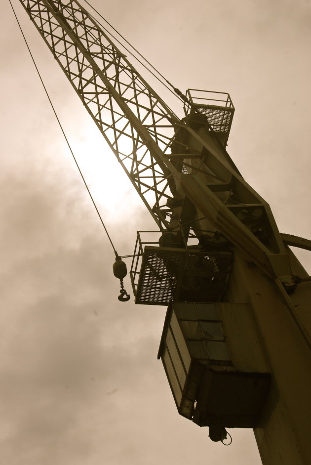 Oude havenkraan in tegenlicht