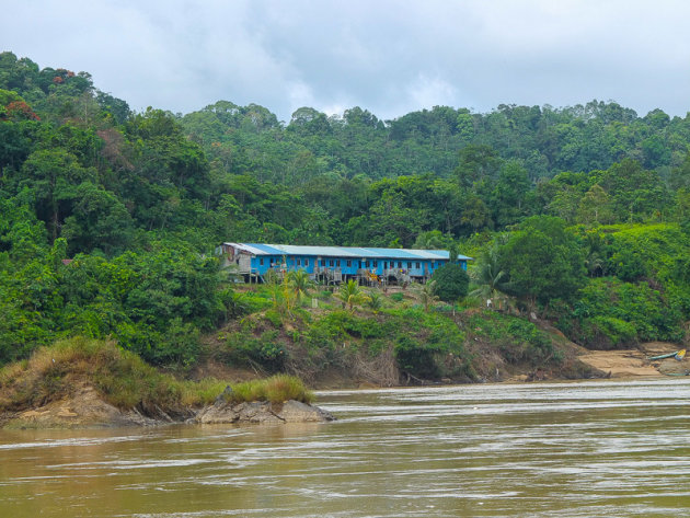 Weg van de bewoonde wereld in Borneo, varen over de rivier langs de longhouses