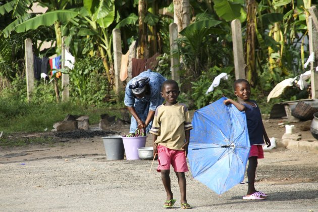 Little boys playing while mother is doing the laundry