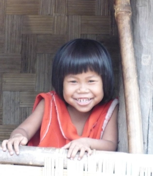 Vrolijk meisje in bergdorpje in Laos
