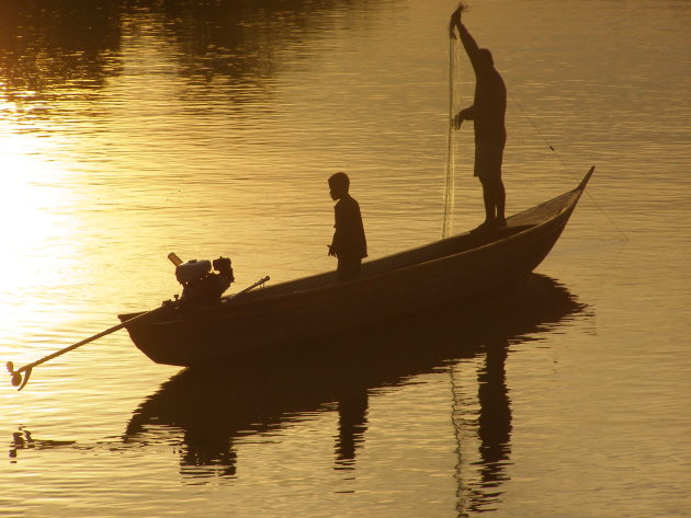 Vissersbootje bij zonsondergang