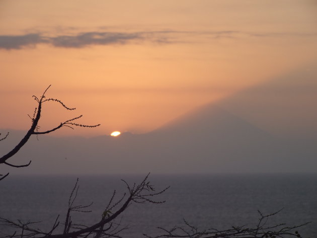 Ondergaande zon achter vulkaan van Bali