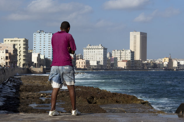 Een cubaanse jongen geniet van het uitzicht op de kade