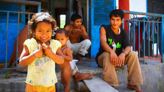 Meisje met koekje en dr familie erachter. Dorpje in de bergen grens cambodja vietnam.