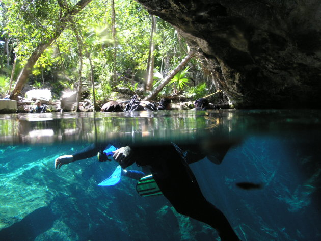 Half boven en half onder water in de Chac Mool Cenote