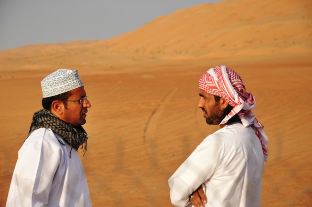 Twee Omani's voeren serieus gesprek midden in de woestijn