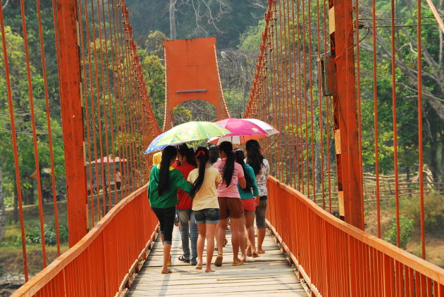 Meisjes met umbrella's op een rode brug