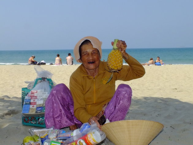 Oude vrouw op het strand die al haar hele leven producten verkoopt op het strand. 