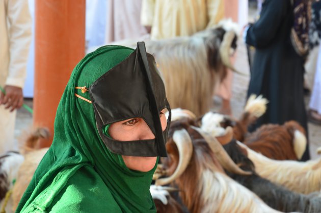 Vrouw in traditionele kleding op de geitenmarkt in Nizwa