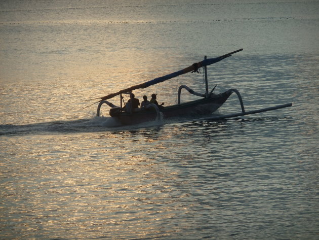 Huis waarts kerende vissers in hun typische vissersbootjes bij ondergaande zon.