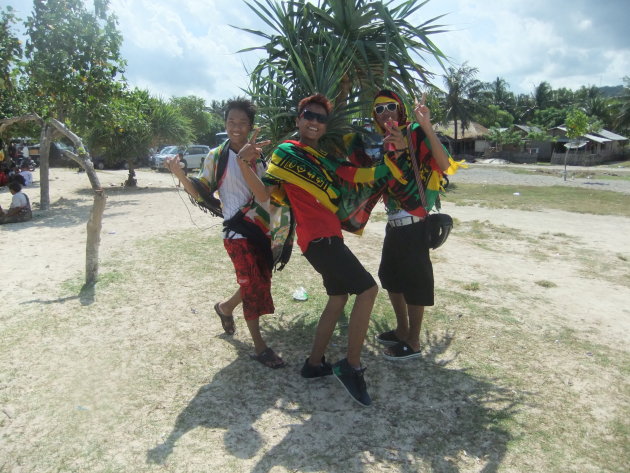 Drie vrolijke jongens op het strand bij het plaatsje Kuta.