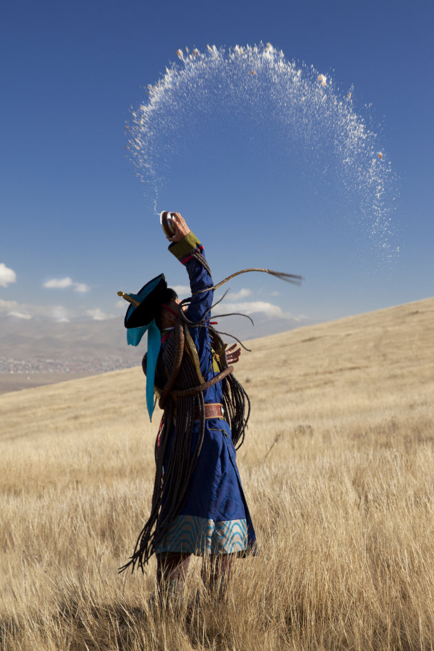 Mongoolse sjamaan brengt een offer aan de aarde