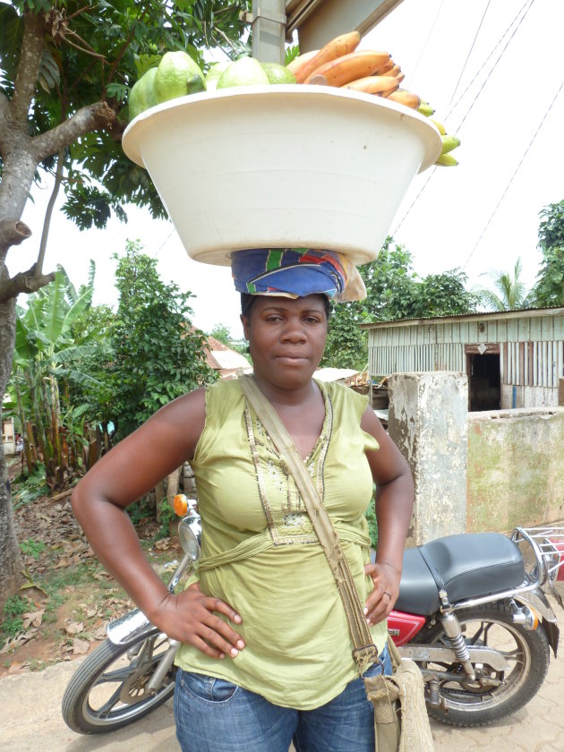 Vrouw lopend door het centrum Sao Tomé stad met fruit.