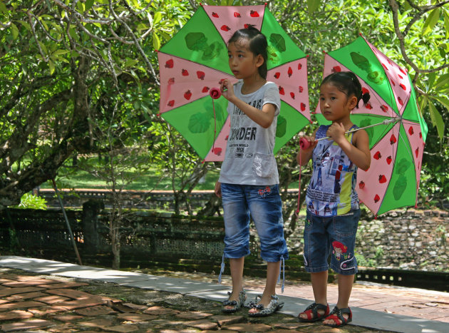 Meisjes met aardbeienparasols/-plu's Hué