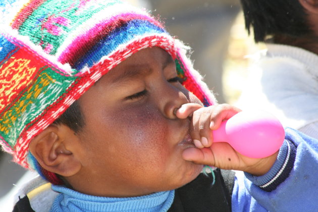 Jongentje bij het titicaca meer met een net gekregen ballon