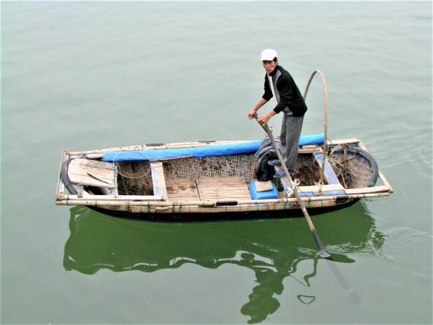 Een visser op zijn bamboebootje.