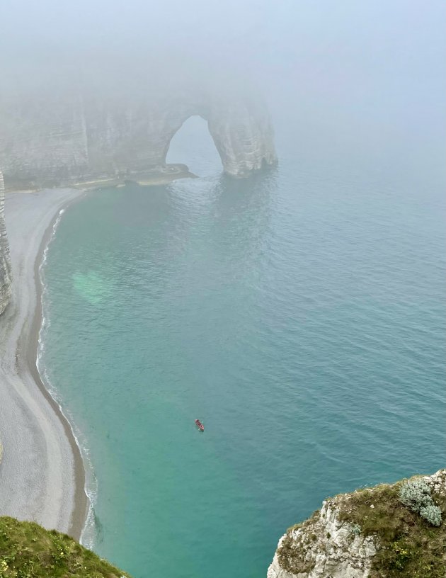 Eenzame kanoër langs de rotskust van Etretat