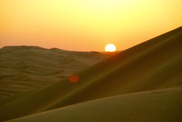 De zon in het zand zien zakken..